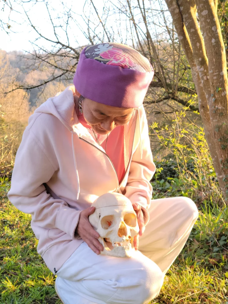 Photo de Catherine Prot tenant un crâne dans la nature